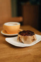 CINNAMON BUN AND LATTE ON THE TABLE