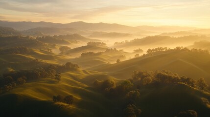 Fototapeta premium Golden sunrise over rolling hills and misty valley.