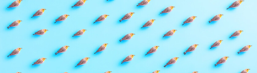 Fototapeta premium A vibrant, aerial view of small figures swimming in a blue pool, creating a dynamic pattern against the bright backdrop.