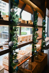 Christmas decoration for restaurant, shopping mall, retail store, grocery with blue and white glass spheres, leafy plants arrangement and chain lights on the display