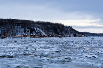 Cliff and houses along the Chemin de la Plage Jacques-Cartier in the Cap-Rouge sector seen with a partly frozen St. Lawrence river during a blue hour winter morning, Quebec City, Quebec © Anne Richard