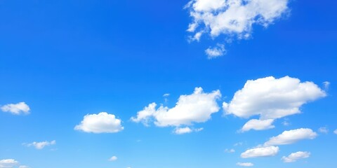 Fototapeta premium Clear blue sky with fluffy white clouds scattered across the horizon on a sunny spring day, horizon, field