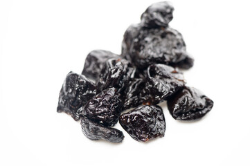 Dried plums scattered on a white surface evoke natural sweetness and culinary creativity