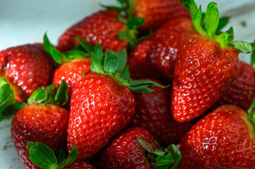 Freshly harvested strawberries glistening in the sunlight on a rustic wooden table