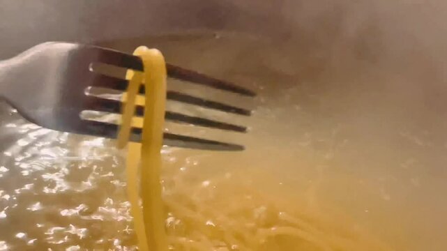 Freshly cooked spaghetti lifted from boiling water, glistening and perfectly al dente, ready to create a comforting pasta dish