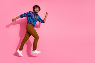 Full size photo of nice young man run jump empty space wear shirt isolated on pink color background