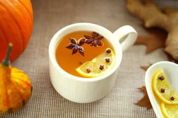 White tea cup with hot herbal tea. Anis, lemon and cloves for herbal tea.