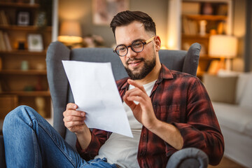 adult happy man sit in the armchair read document with a good news
