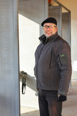 An instructor of shooting in a beret at a shooting range smiling