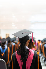 A rear view of graduates seated in rows during a graduation ceremony