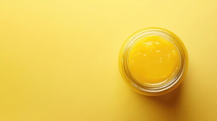 Lemon curd in glass jar on light yellow background perfect for use on pancakes or cookies vibrant citrus flavor concept.
