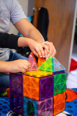 Mom and daughter playing and building with magnetic tiles
