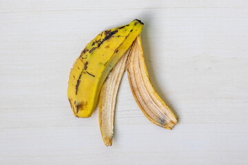 Yellow ripe banana skin on a wooden background. Top view.