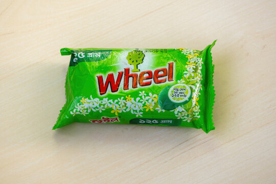 Wheel laundry soap bar for washing clothes, packaged in a green wrapper, displayed on a wooden background. On January 12, 2025, in Kishoreganj, Bangladesh