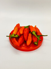Small chili. Cayenne pepper on a red container.