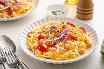 Spaghetti squash with chickpeas and tomatoes topped with red onion, low carb vegan recipe idea