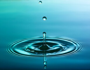 water droplets fall onto a still blue green surface of teal water with ripples and reflections sea fluid