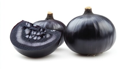 Black garlic bulbs and a sliced piece showing the inner texture on a white background with copy space