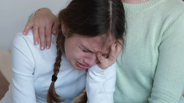 Mom comforting depressed crying preteen daughter at home. Bonding between child and mother. Parent supporting sad little girl having problem. Family support concept