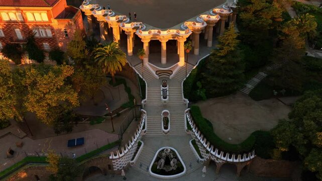 Revealing drone shot of Park Guell in Barcelona, aerial shot at sunrise, tourism in Barcelona. Antonio Gaudi architecture. Dawn in Barcelona park Guell, Spain