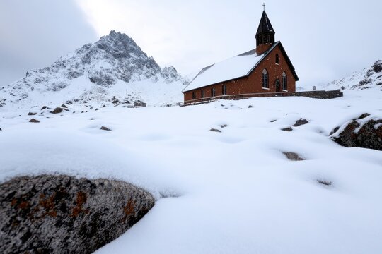 A striking red church nestled in a snowy landscape, framed by towering mountains, symbolizing warmth and faith amidst the cold winter environment.
