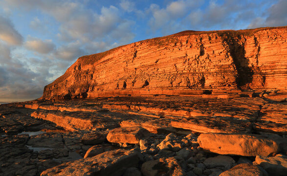 Golden evening light on the limestone cliffs, Dunraven Bay, Southerndown, Vale of Glamorgan, Wales, United Kingdom