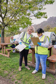 Two female volunteers checking list during packaging donation boxes