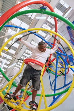 Teenager with cerebral palsy on gyroscope in science center