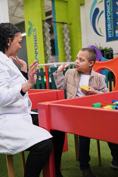 Little boy playing with instructor at science center