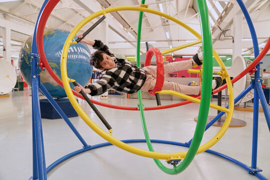 Boy having fun on gyroscope at science center