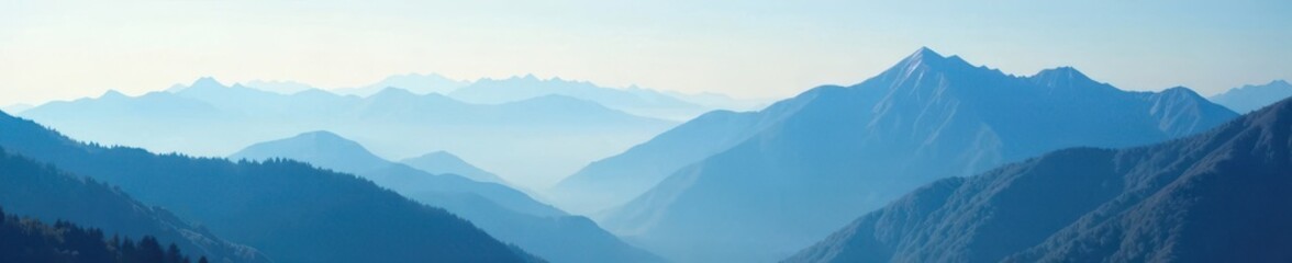 Misty morning on mountain peaks under blue sky, mist, foggy