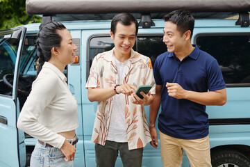 Man using gps on his smartphone for journey on car with friends