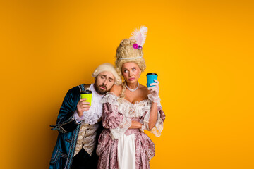 Vintage-dressed couple holding coffee cups in modern setting