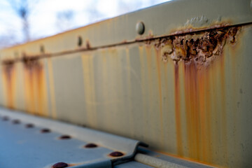 Rusted and peeling paint on an electrical transformer exposed to the elements. 