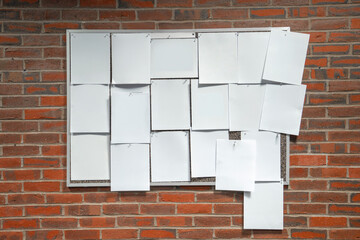 post board on the wall full of blank white papers