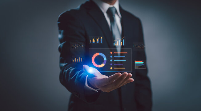 Businessman's hands work on business data analysis using statistical graphs, managing structured data on dashboards, and evaluating and measuring the performance of business organization