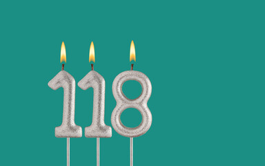 Birthday candle number 118 - Card on a green background.