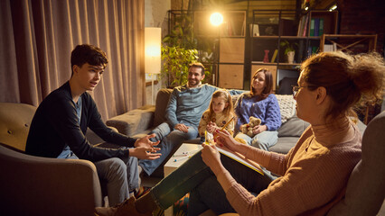 Fototapeta premium Teen boy talks to psychologist, discussing concerns, while his family listens attentively in the background. Maintaining productive communication. Concept of psychology, assistance, therapy