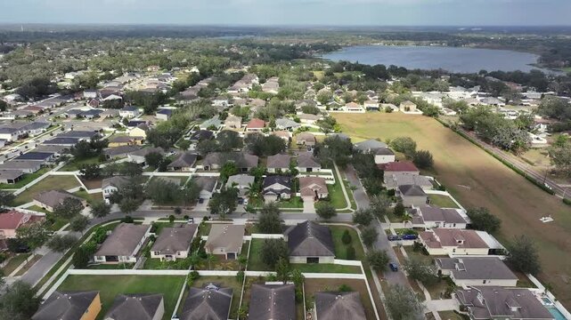 Aerial establishing shot of noble villas in Brandon, Tampa, Florida. Sunny day with lake in distance. Expensive mansions in suburb district. Wide shot.