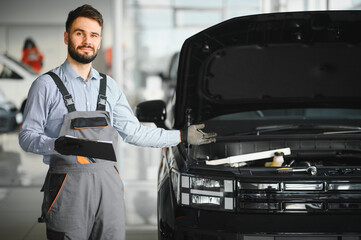 Auto mechanic holding clipboard checklist the car at mechanic shop