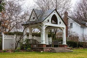 Elegant White Garden Pavilion With Benches in a Serene Green Outdoor Setting