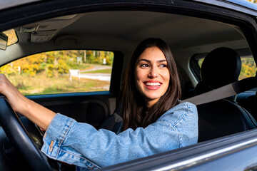 The woman drives with a smile, enjoying every moment of the journey ahead