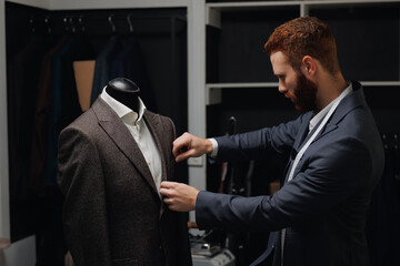 Professional tailor creating high quality tailored suit in luxury tailoring atelier. Concept...