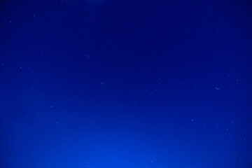 Starry night sky with deep blue horizon and subtle stars