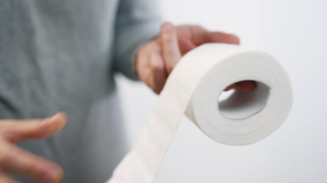 Man holding a roll of toilet paper
