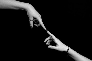 deux mains se rejoignant par l'index avec finesse en noir et blanc sur fond noir © Esta Webster