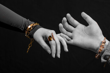 deux mains en noir et blanc avec des bijoux cuivrés se tenant par le petit doigt  © Esta Webster