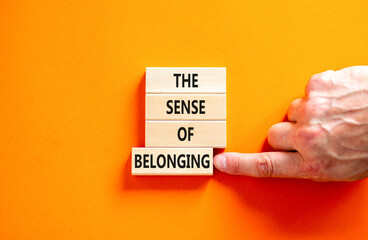 The sense of belonging symbol. Concept words The sense of belonging on beautiful wooden blocks. Beautiful orange table orange background. Business and the sense of belonging concept. Copy space.