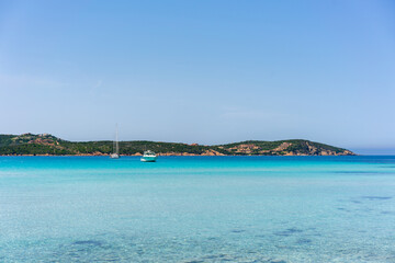 Grande Pevero beach with turquoise clear water and boats in Sardinia, Italy