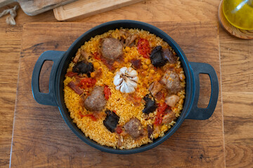 baked rice pan, a traditional Valencian dish, based on rice and stew ingredients. Top view with wooden background
